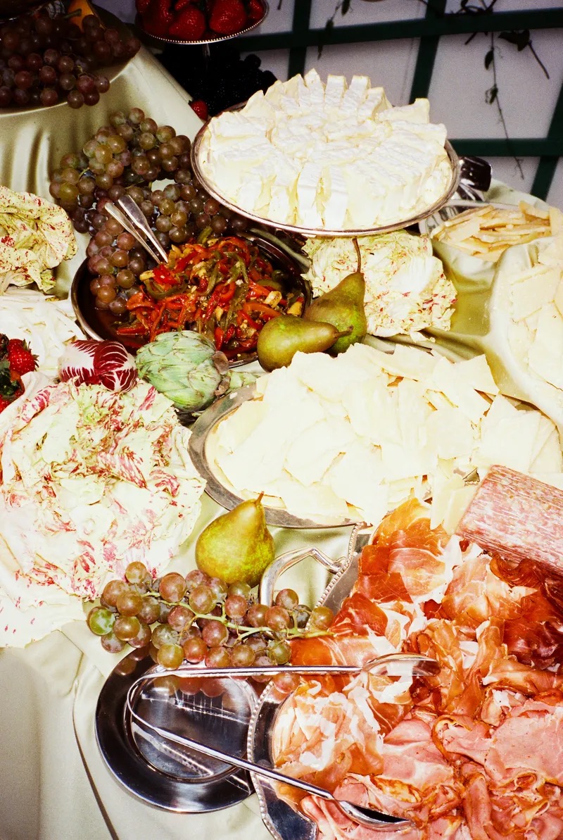 Detail shot of premium charcuterie, artisanal cheeses, grapes and gourmet accompaniments